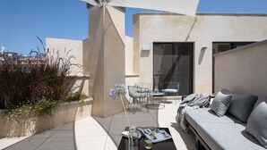 A modern outdoor seating area with a sofa, chairs, and a table. - Hommyhome Tetuán 15 Boutique - 202 (Sevilla)
