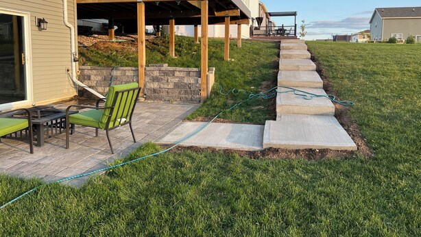 A house with a covered patio, outdoor seating, and a stone retaining wall. - Home away from home!!! (Sun Prairie)