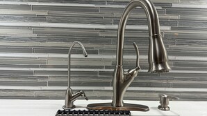 A modern kitchen with a stainless steel faucet, a sink with a black drain, and a tiled backsplash. - Home away from home!!! (Sun Prairie)