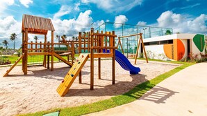 A playground with a climbing structure, slides, and a fenced area. - Mana Beach Experience B221- Carpediem (Ipojuca)