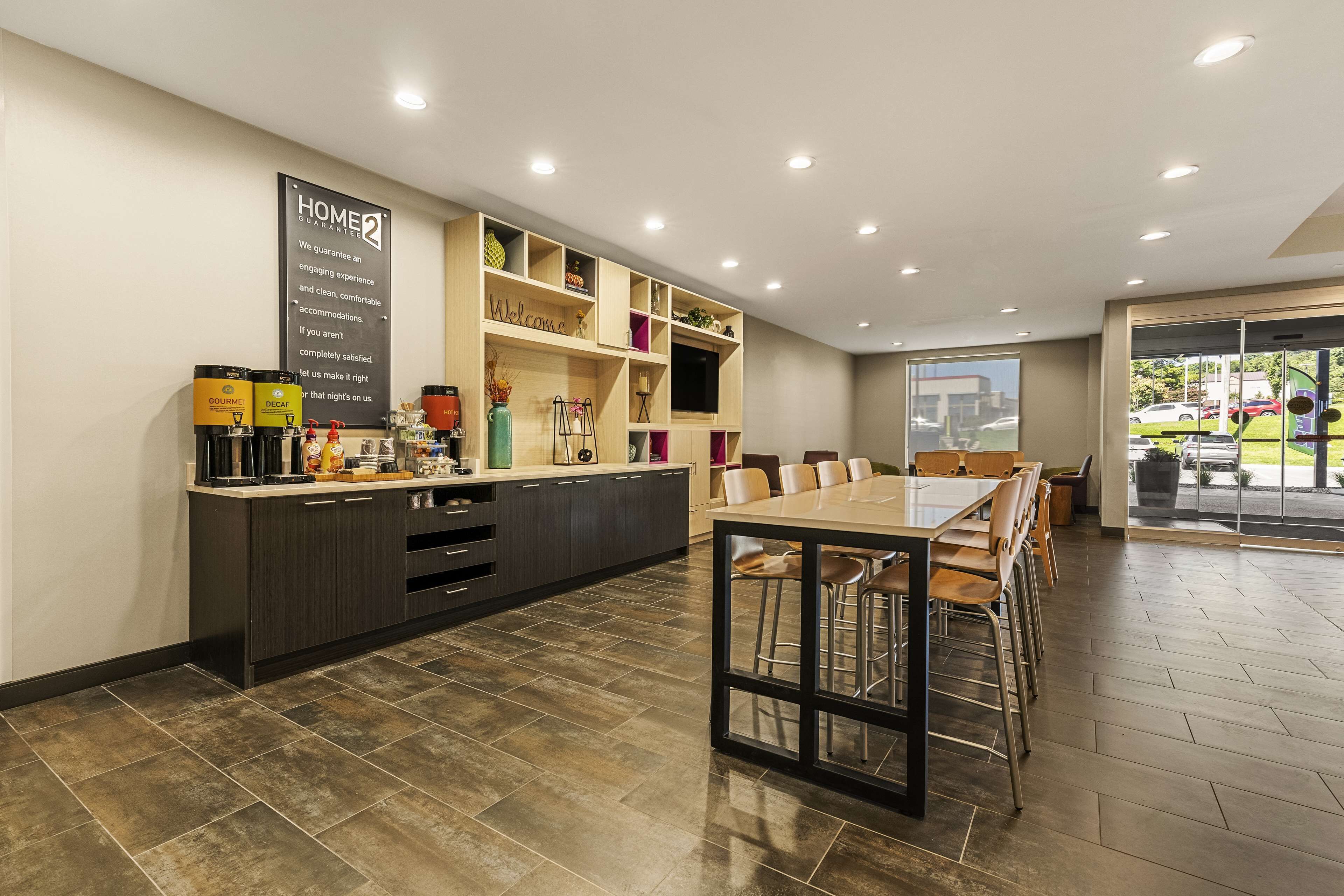 A modern kitchen with a central island, built-in shelves, and a dining area with a large table and chairs.