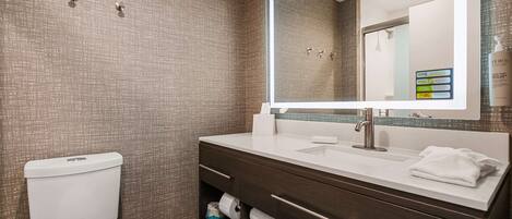 A modern bathroom with a toilet, a sink with a mirror, and a towel rack.