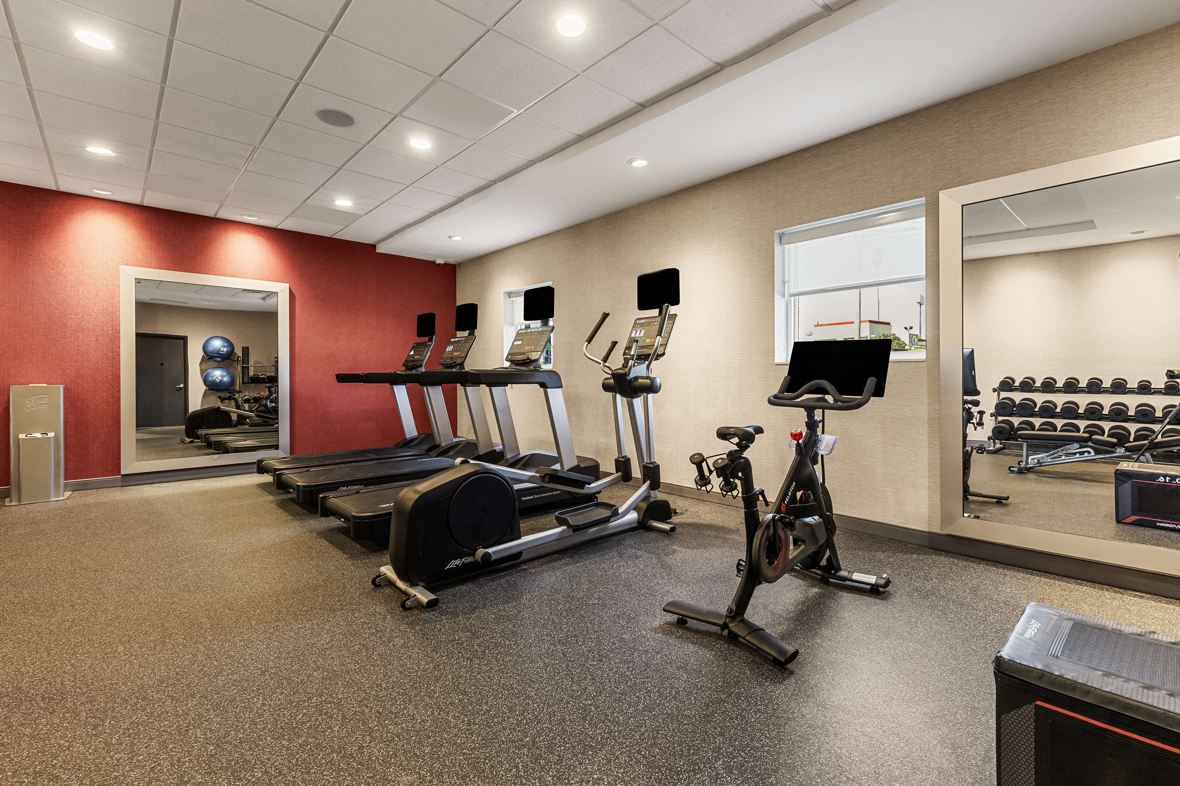 A gym with treadmills, elliptical machines, and a stationary bike.