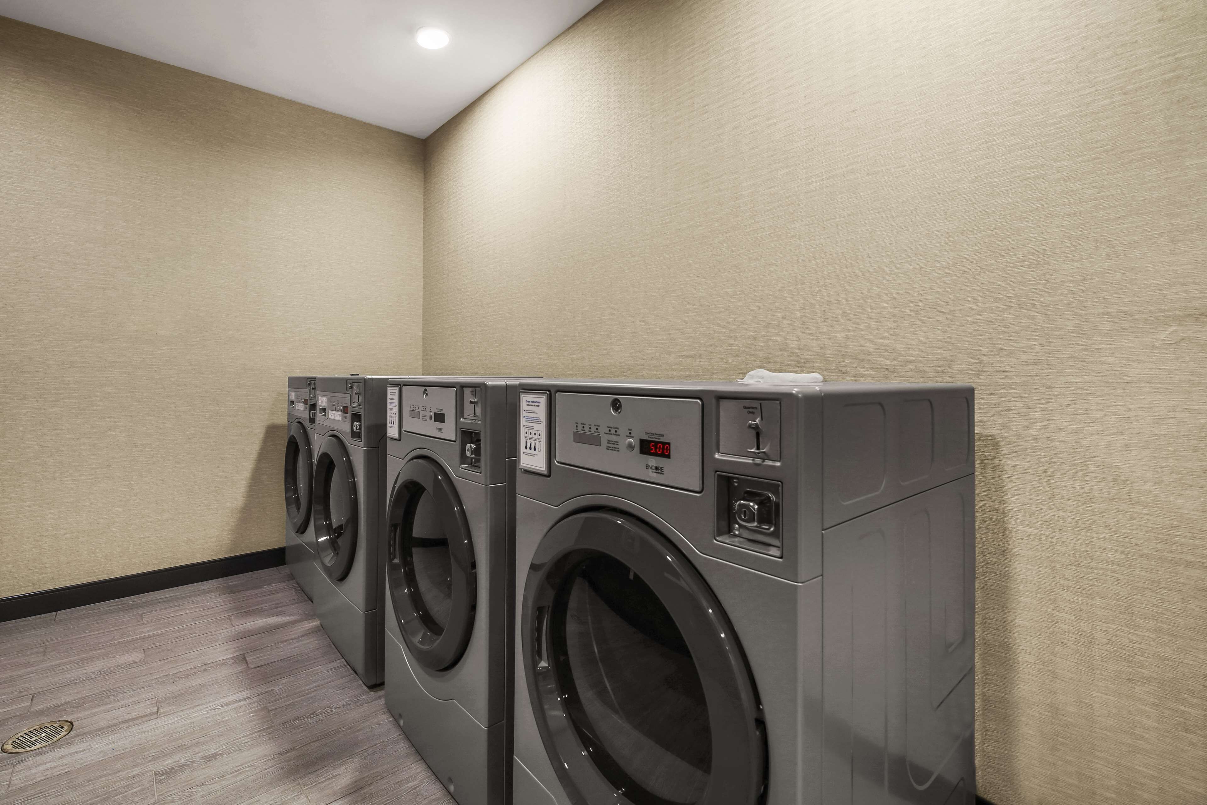 Diverses rentadores grises penjades a la paret d'una habitació d'hotel.