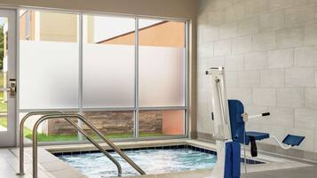 A spa area with a hot tub, a window with frosted glass, and a pool lift.