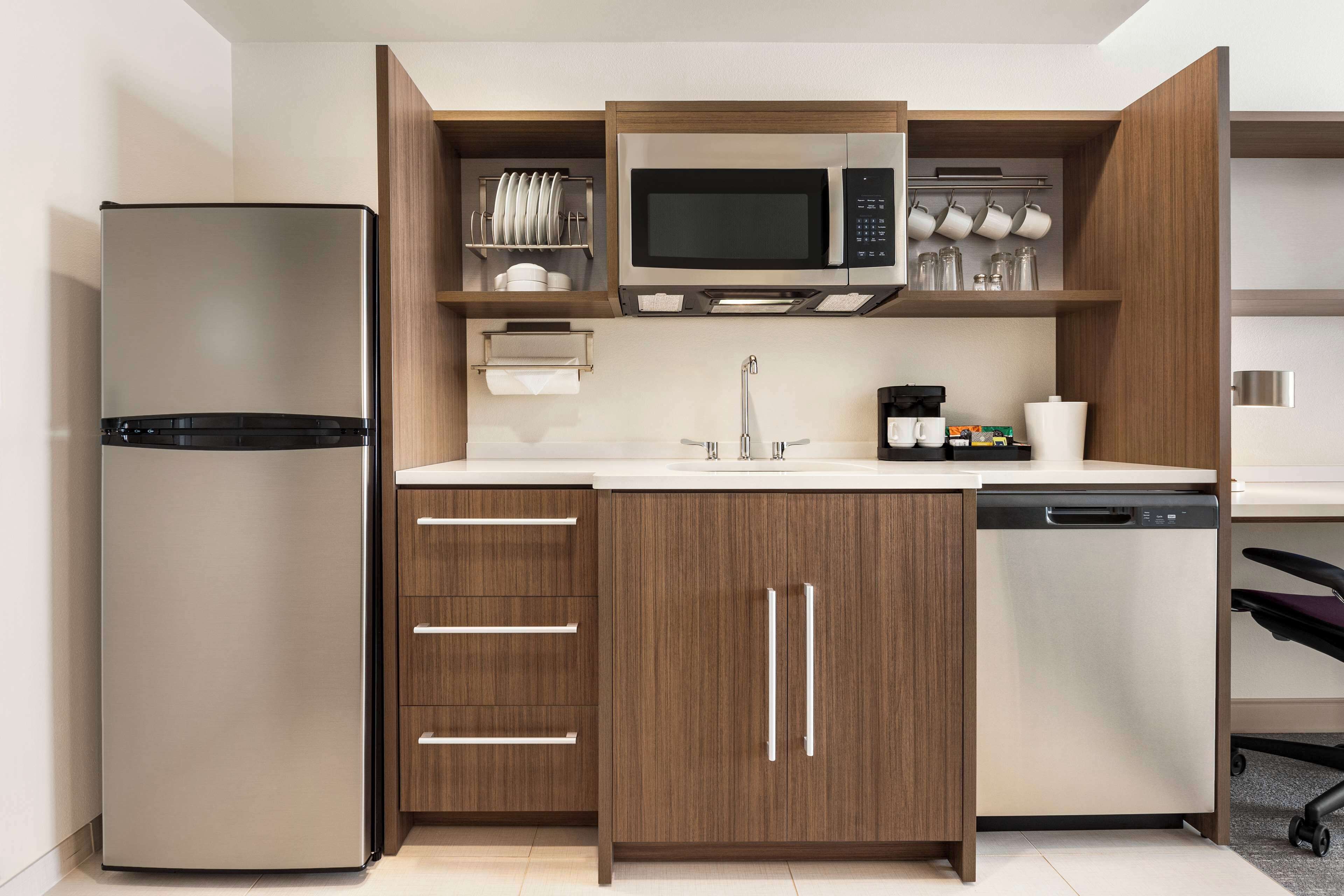 A compact kitchen with a refrigerator, microwave, sink, and dishwasher.
