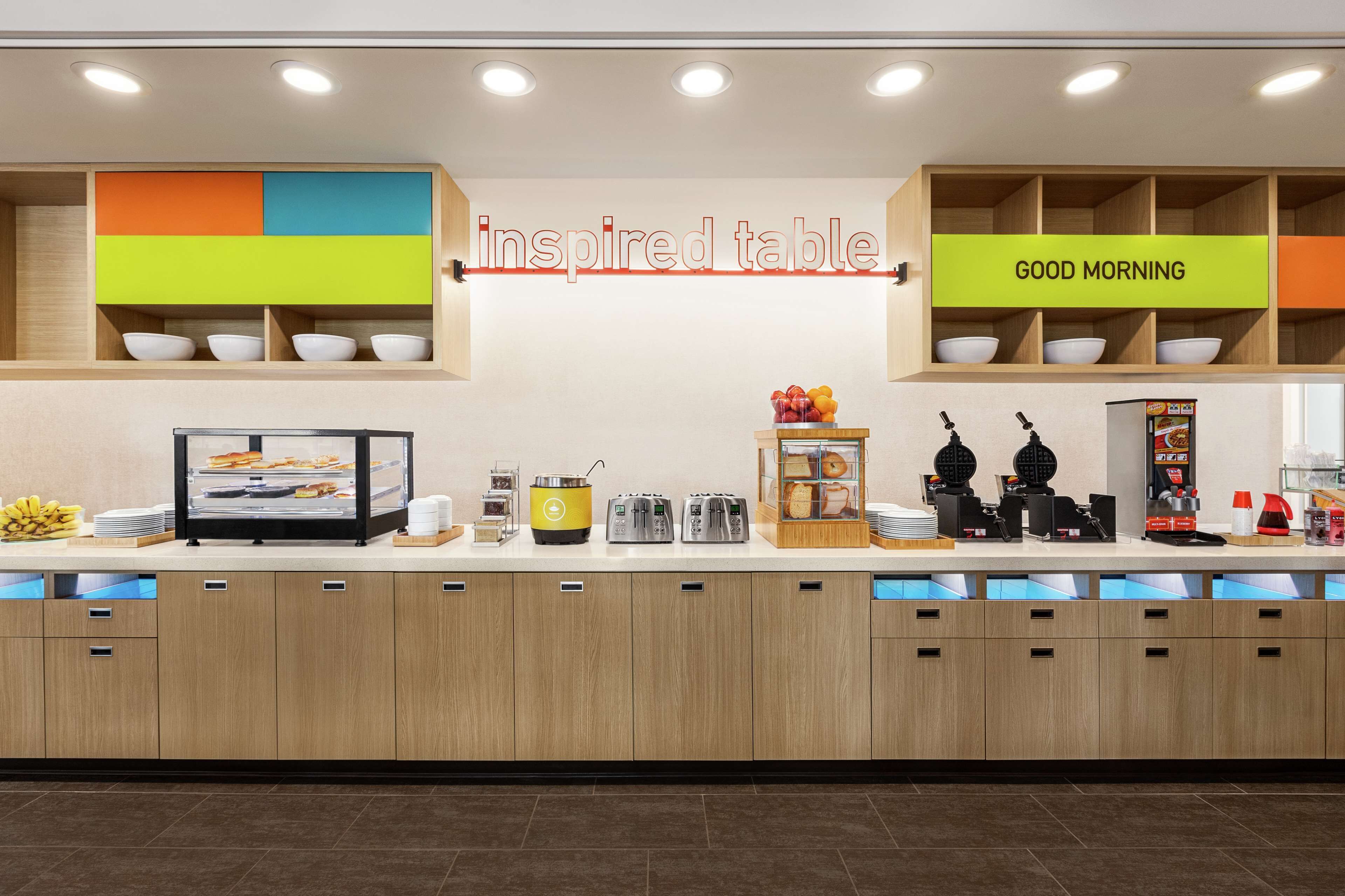A breakfast bar with a sign reading "inspired table" and "GOOD MORNING".