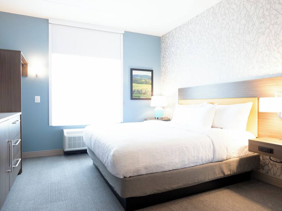 Ein Hotelzimmer mit Bett, Nachttischen, einem Kleiderschrank und einem Fenster.