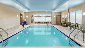 An indoor swimming pool with clear blue water, surrounded by beige walls and a tiled floor. - Home2 Suites by Hilton Leesburg (Leesburg)