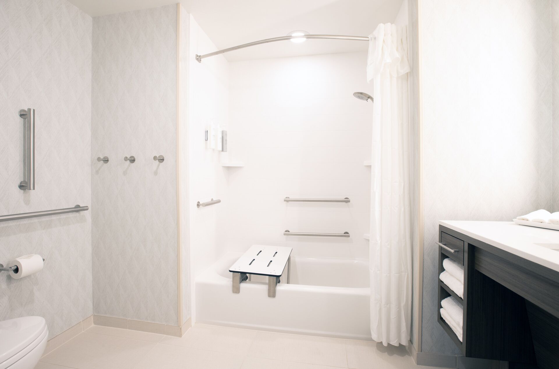 A modern bathroom with a shower, toilet, and vanity.