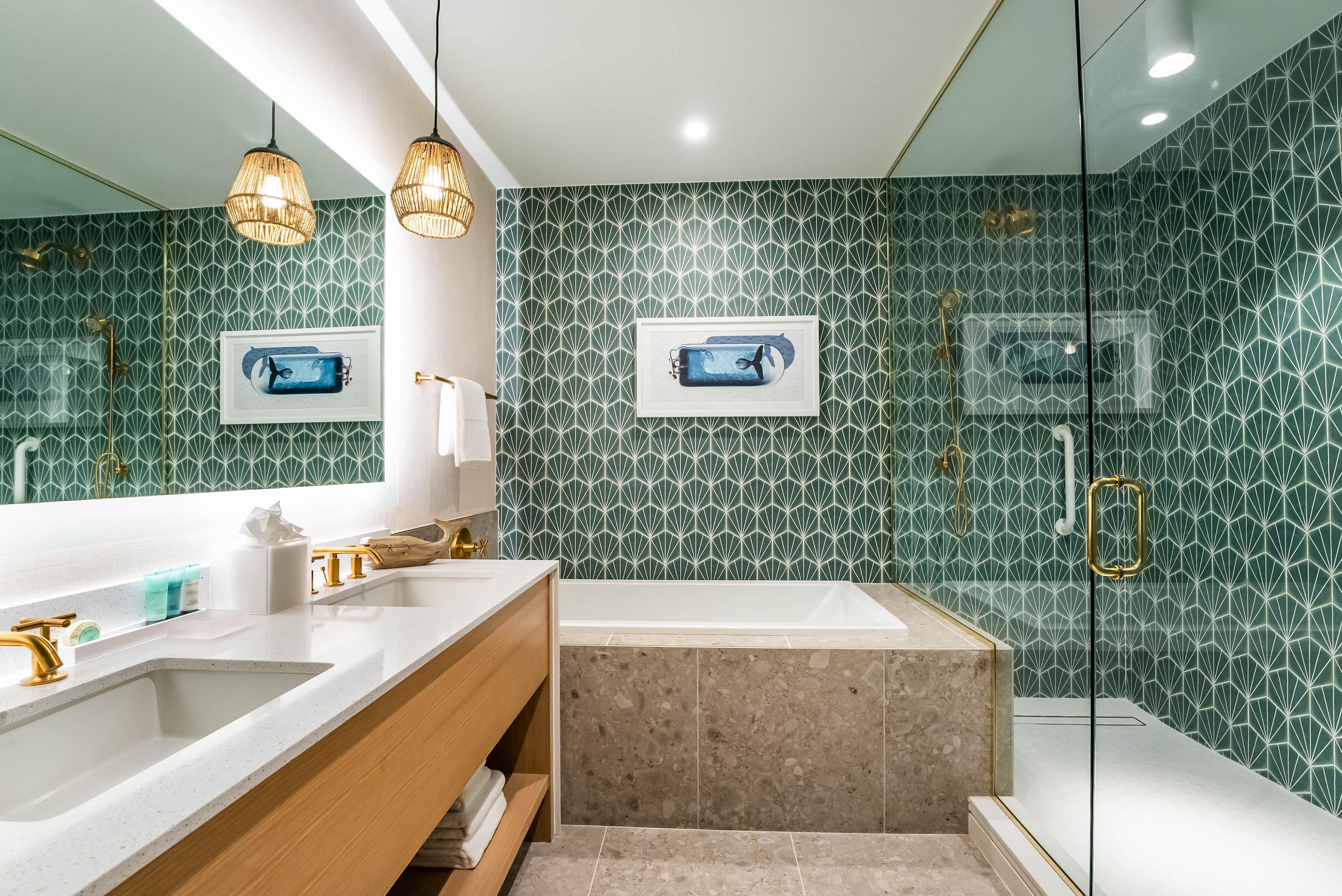 Un baño moderno con un amplio tocador, una bañera independiente y una ducha con mampara de vidrio.