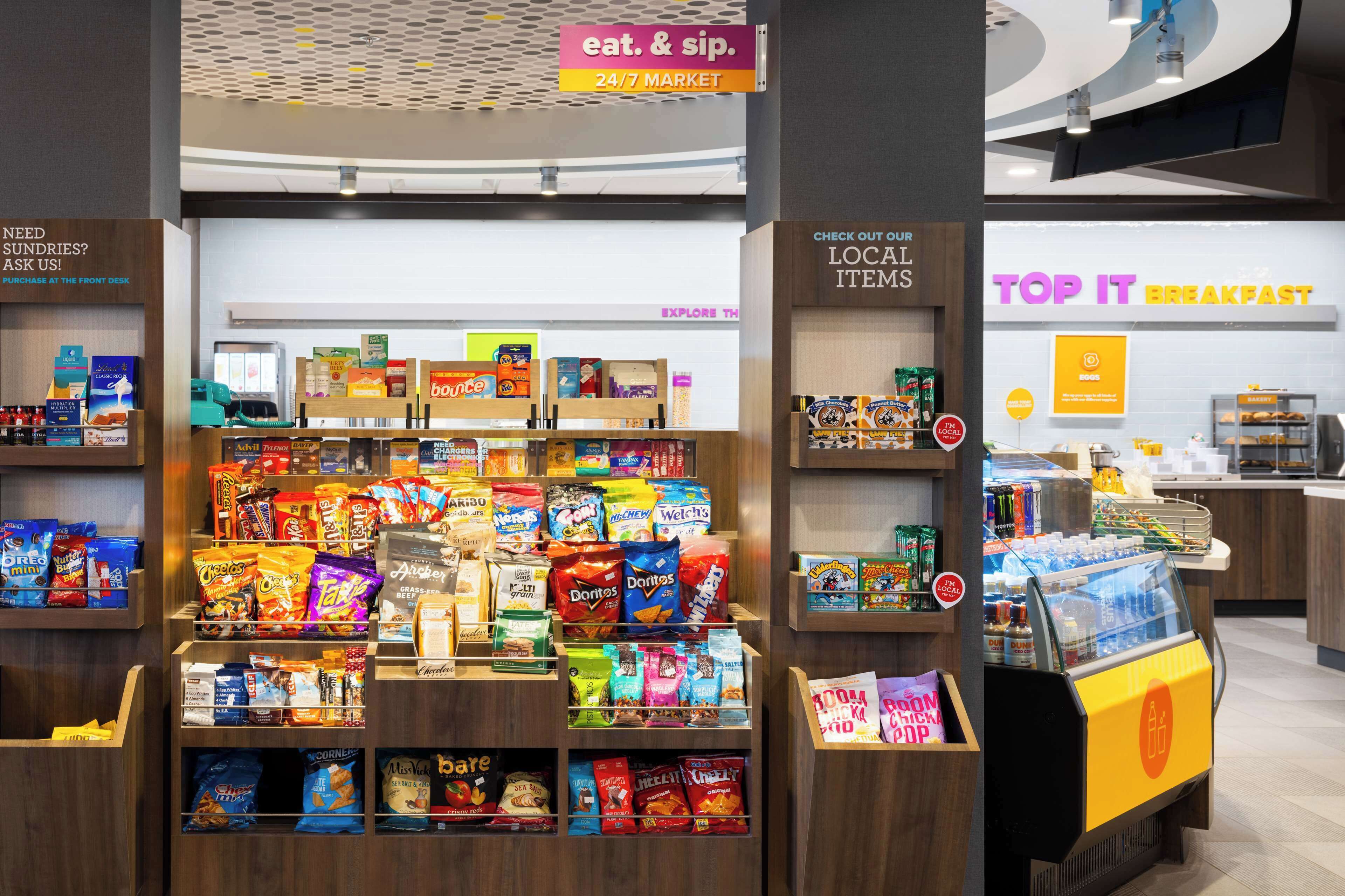 A snack display with various brands and a 24/7 market sign.