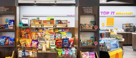 A snack display with various brands and a 24/7 market sign.