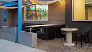 Un espace extérieur aménagé avec des sièges, une fresque murale, une table et des chaises.