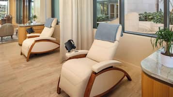 Relax in style with plush leather recliners and a serene view of the outdoor area.