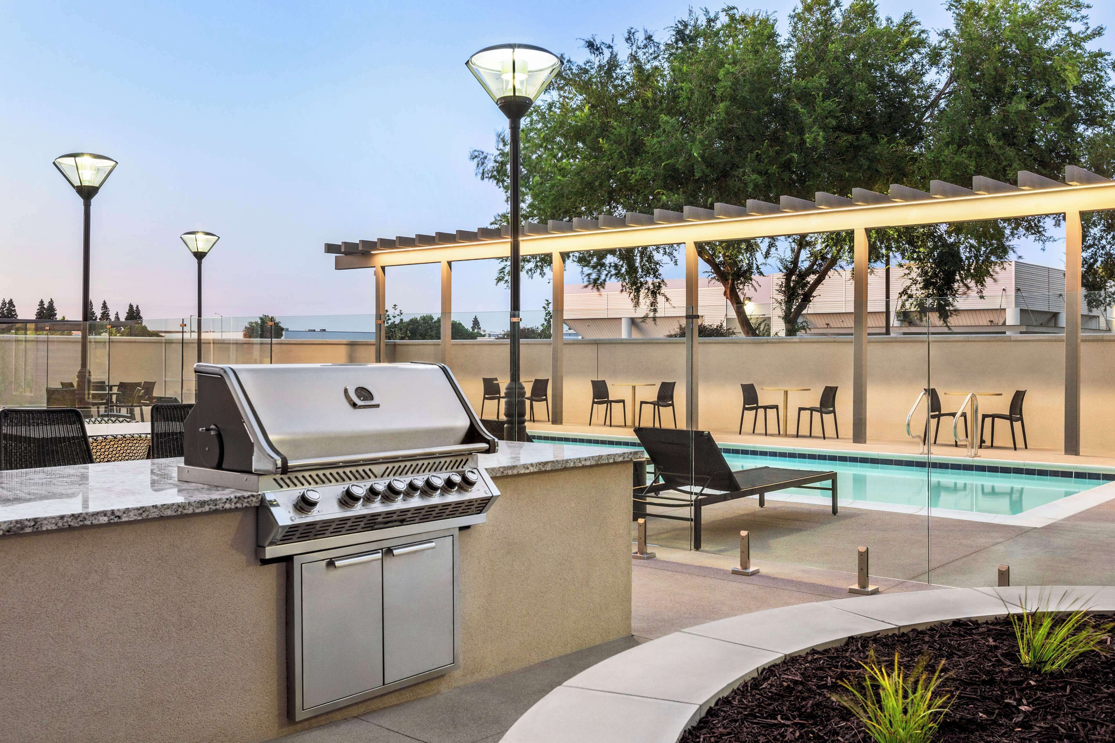 An outdoor pool area with a grill and seating.