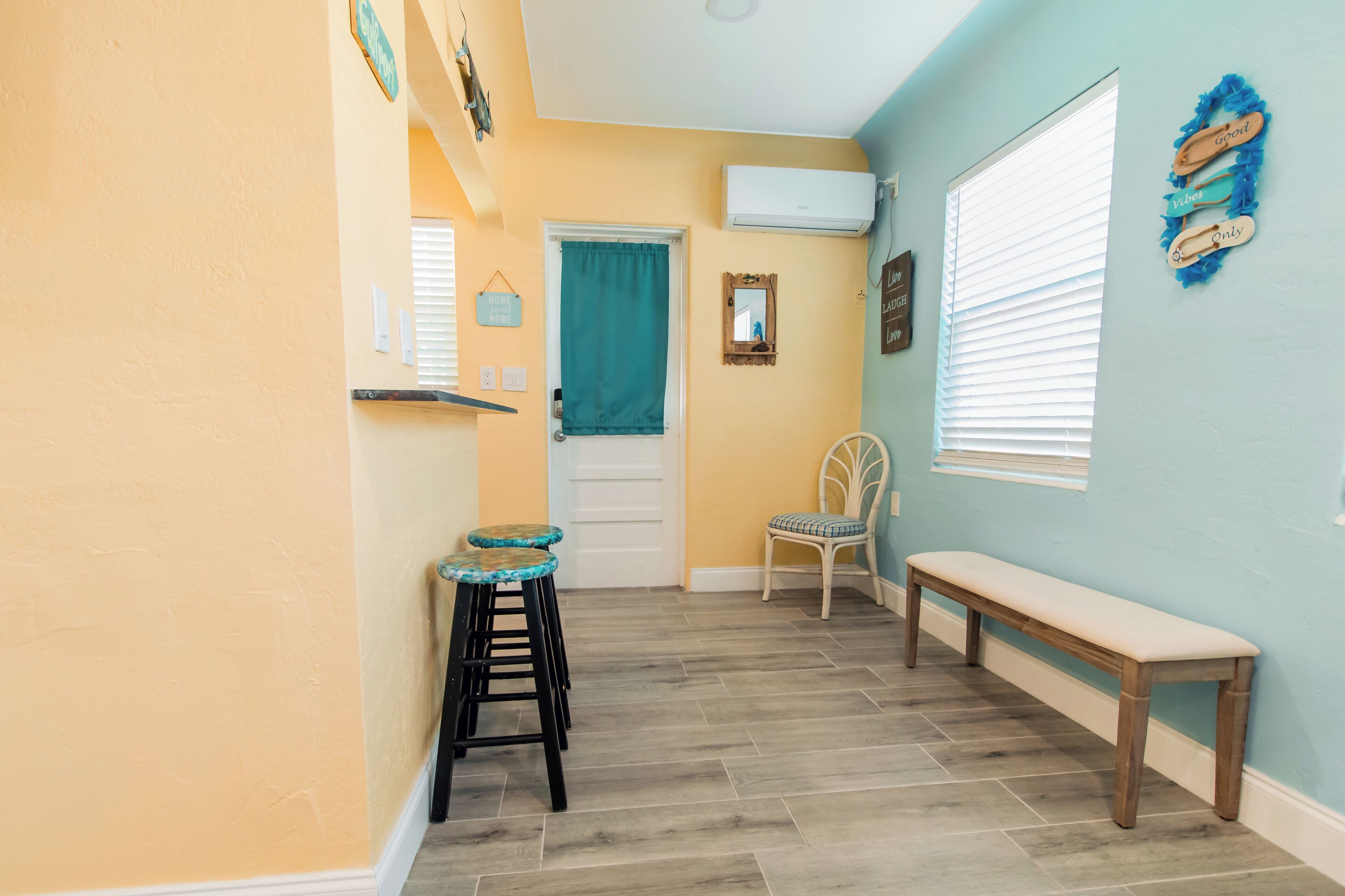 A hallway with a bench, a chair, and a small stool.