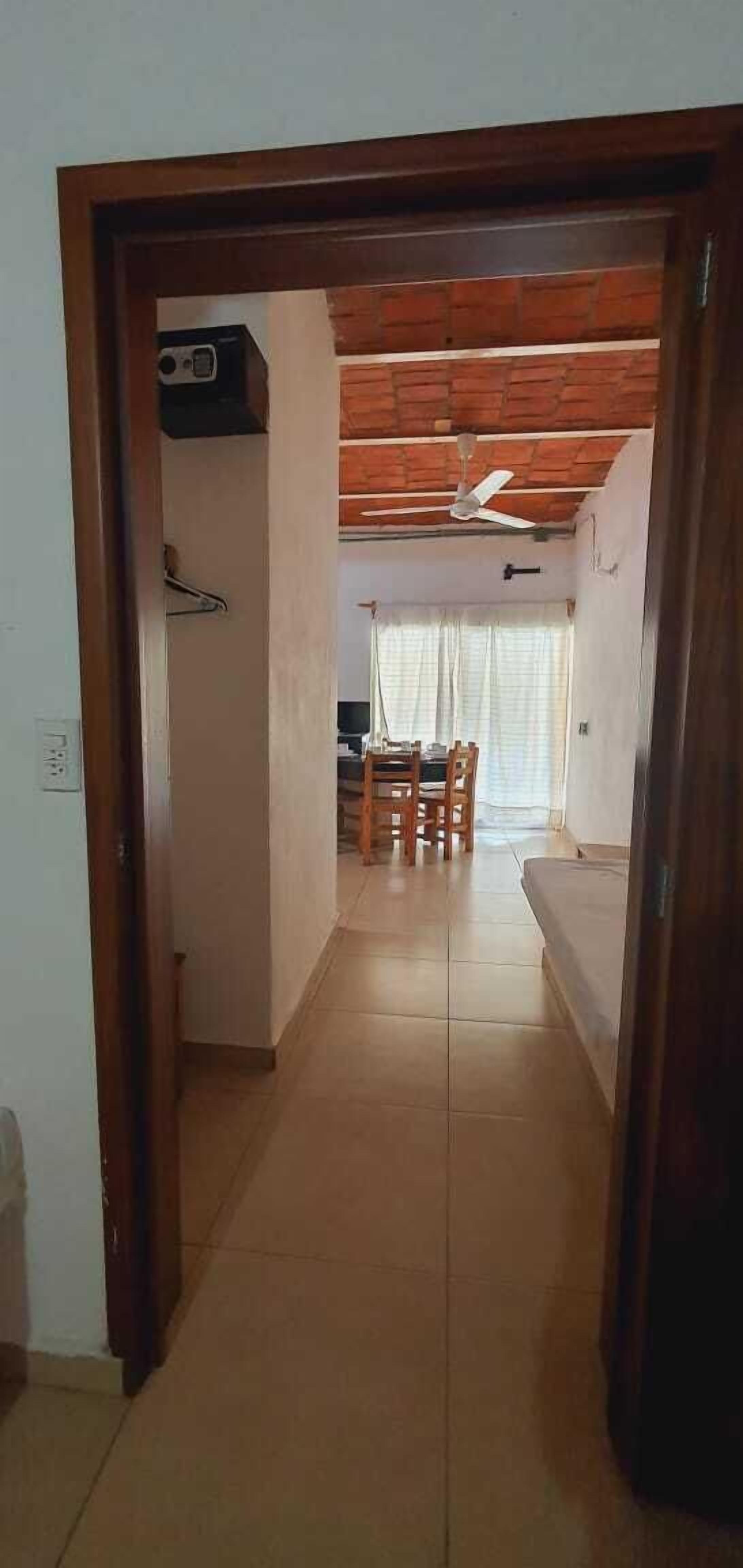 Un pasillo que conduce a un comedor con ventilador de techo, una mesa y sillas.