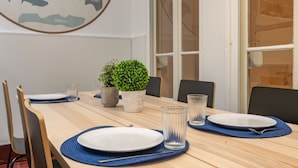 Una mesa de comedor con platos, vasos y una planta en maceta.