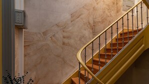 Eine Marmortreppe mit geländerförmigem Handlauf und Holzboden.