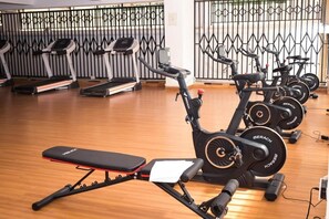 Ein Fitnessraum mit Ergometer, Laufbändern und einer Bank.