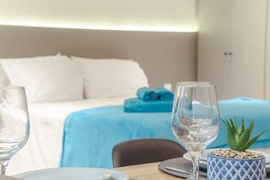 A hotel room with a bed, a table with a glass of water, a small potted plant, and a blue cushion. - Apart no Mardisa Design por Carpediem (João Pessoa)