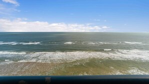 Ein Strand mit Wellen und blauem Himmel.