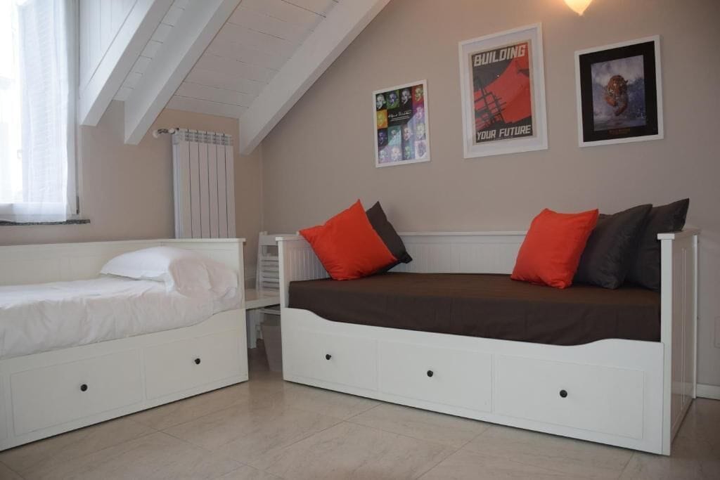Een slaapkamer met twee bedden, een radiator en wanddecoratie.