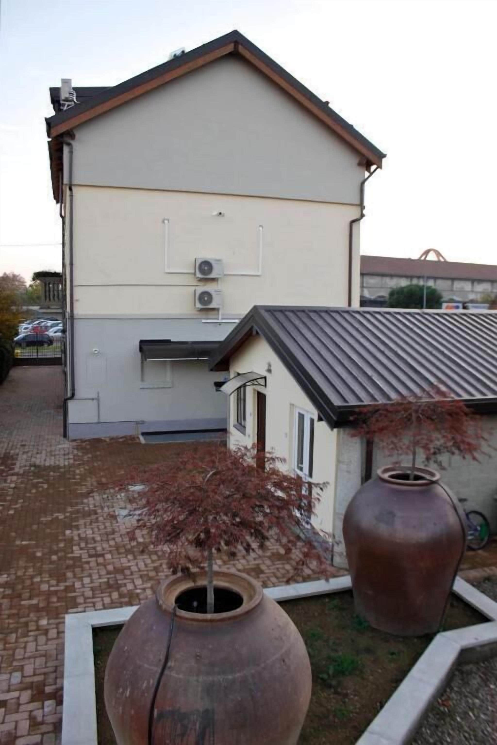 A two-story building with a flat roof and a small attached structure.