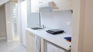 Una cocina moderna con encimera blanca, horno integrado y lavavajillas.