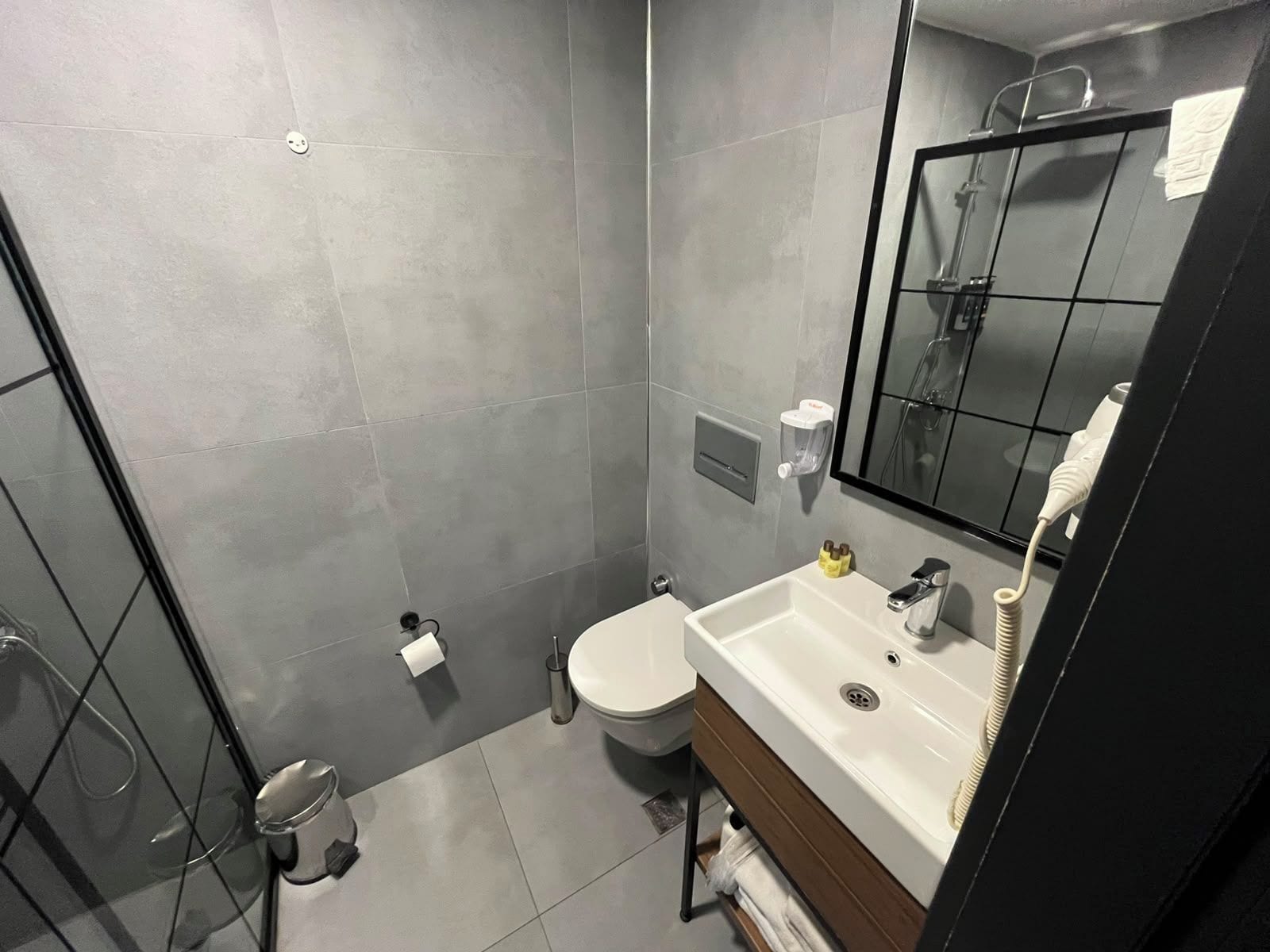 Un baño moderno con inodoro, lavabo y ducha.