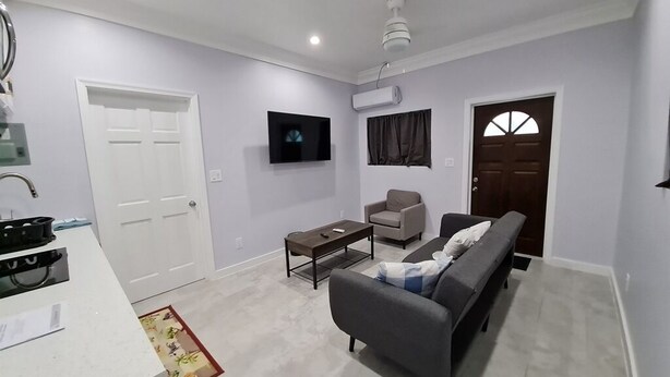 A modern living room with a sofa, a coffee table, a TV, and a fireplace.