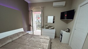 A bedroom with a bed, a dresser, a television, and an air conditioning unit. - Skycity b&b (Naples)