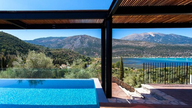 A modern outdoor pool area with a clear view of a mountainous landscape and a body of water. - Villa Naya Desimi in Desimi (Lefkada)