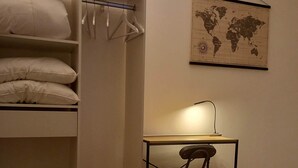 Een slaapkamer met een stapelbed, een bureau met stoel, een wereldkaart aan de muur, en een bed met opgevouwen handdoeken.