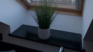A skylight with a view of the sea and a potted plant on a shelf. - 2 Bed Apartment The Priory - Panoramic Sea View (Shanklin)