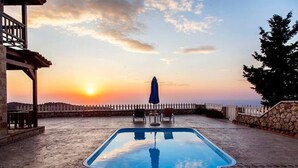 A swimming pool with a sunset view, stone walls, and a white picket fence. - Vissala 5 Alkanna in Chortata (Lefkada)
