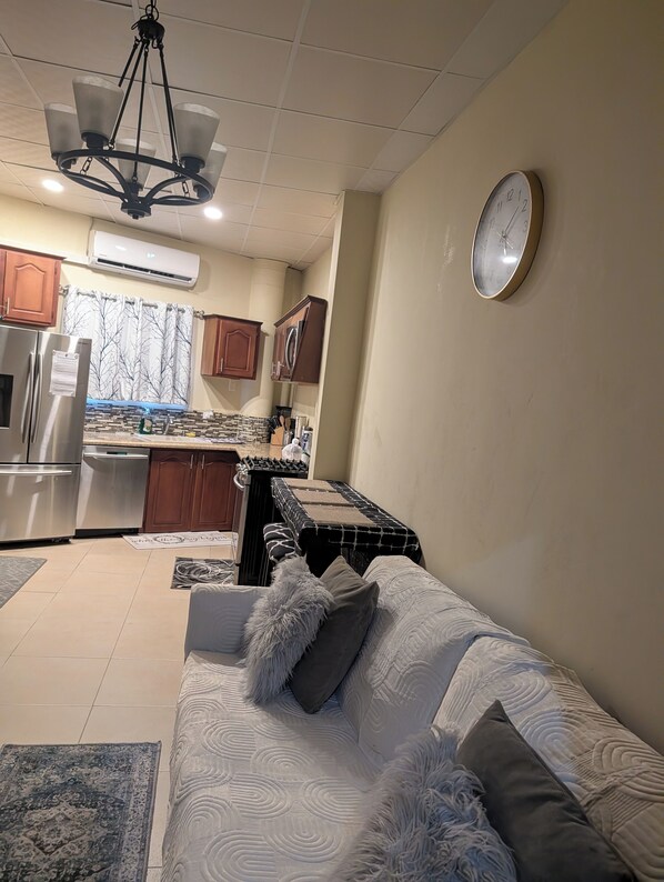 A living room with a sofa, a coffee table, and a kitchen area in the background.