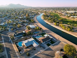 Vista aèria d'una zona residencial amb cases, una piscina i un riu.