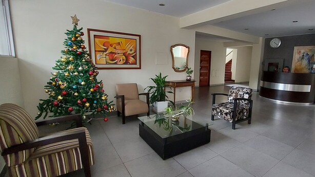 A lobby with a Christmas tree, a reception desk, and a staircase leading to another floor. - Cuarto Privado a 10 Minutos del Parque Kennedy (Lima)
