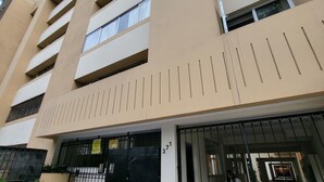 A multi-story building with a gated entrance, a visible number '371' on the gate, and a potted plant in the foreground. - Cuarto Privado a 10 Minutos del Parque Kennedy (Lima)