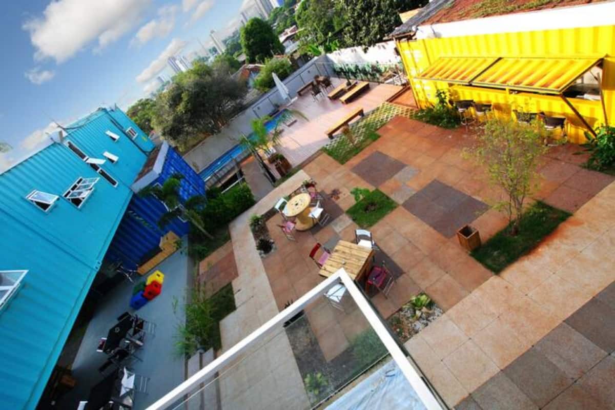 A courtyard with outdoor seating, a yellow awning, and a blue building.
