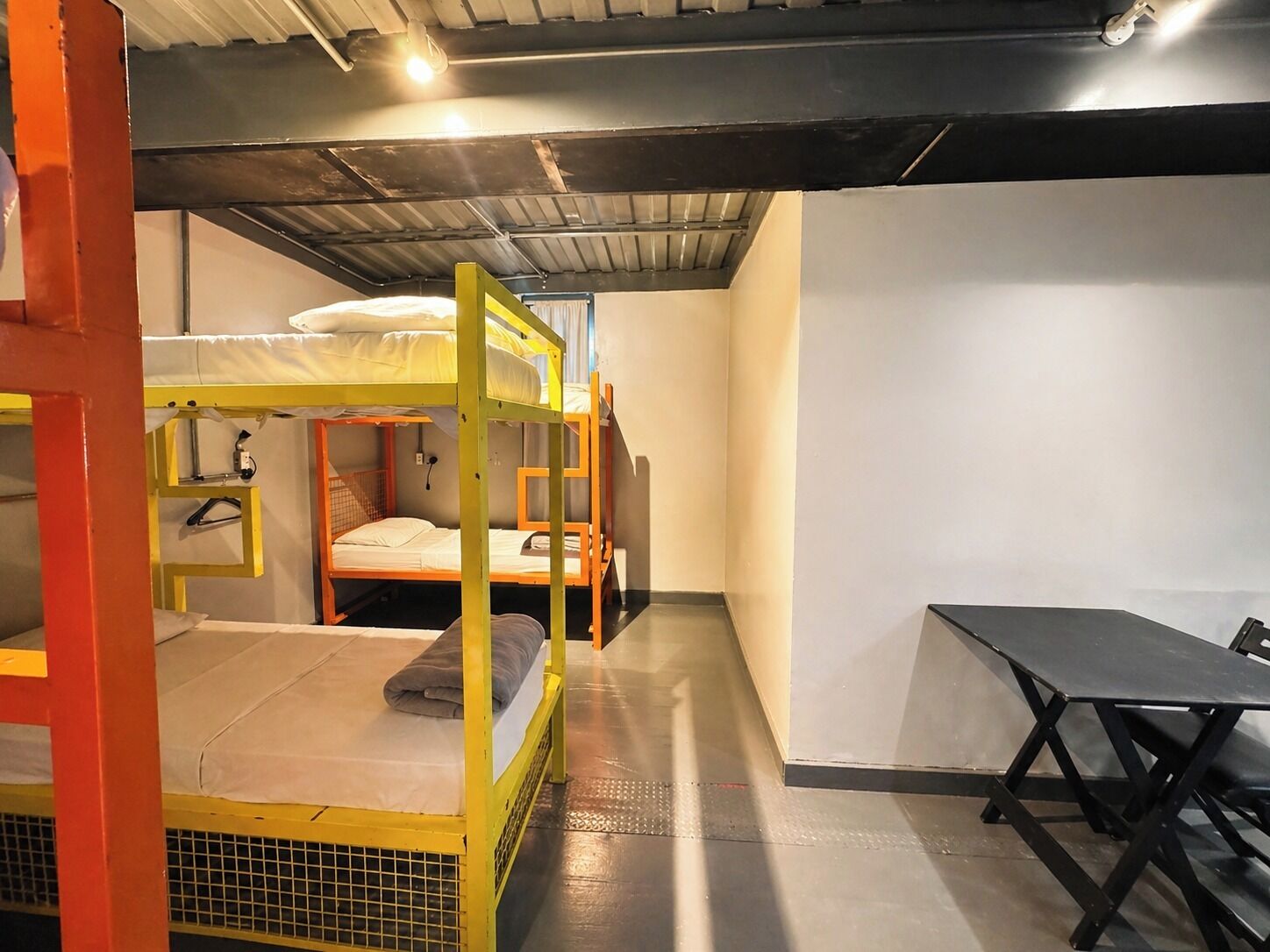 A bunk bed room with a table and a chair.