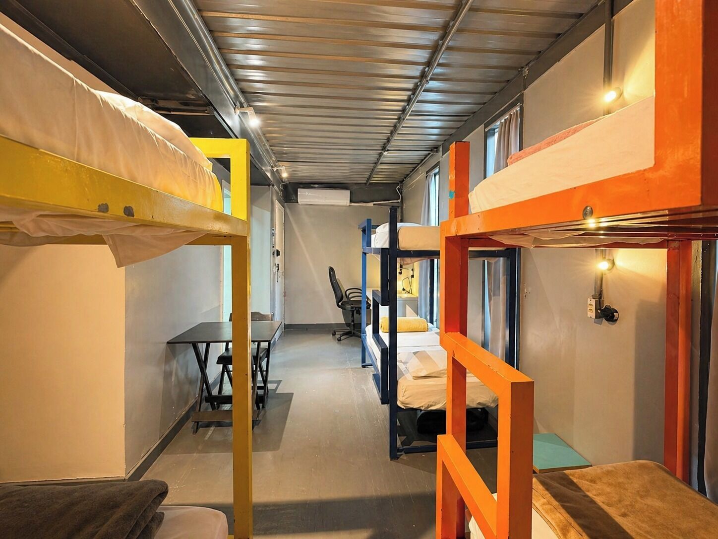 Un dormitorio con literas, un escritorio y una silla.