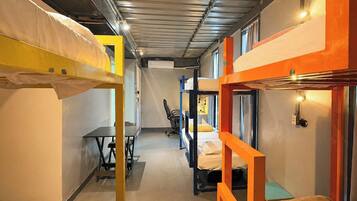 Un dormitorio con literas, un escritorio y una silla.