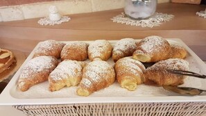 A tray of pastries dusted with powdered sugar, accompanied by a spoon. - ABALON POMPEI RESORT (Pompei)
