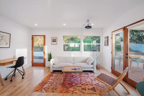 Een moderne woonkamer met een bank, salontafel en een vloerkleed met dessin.