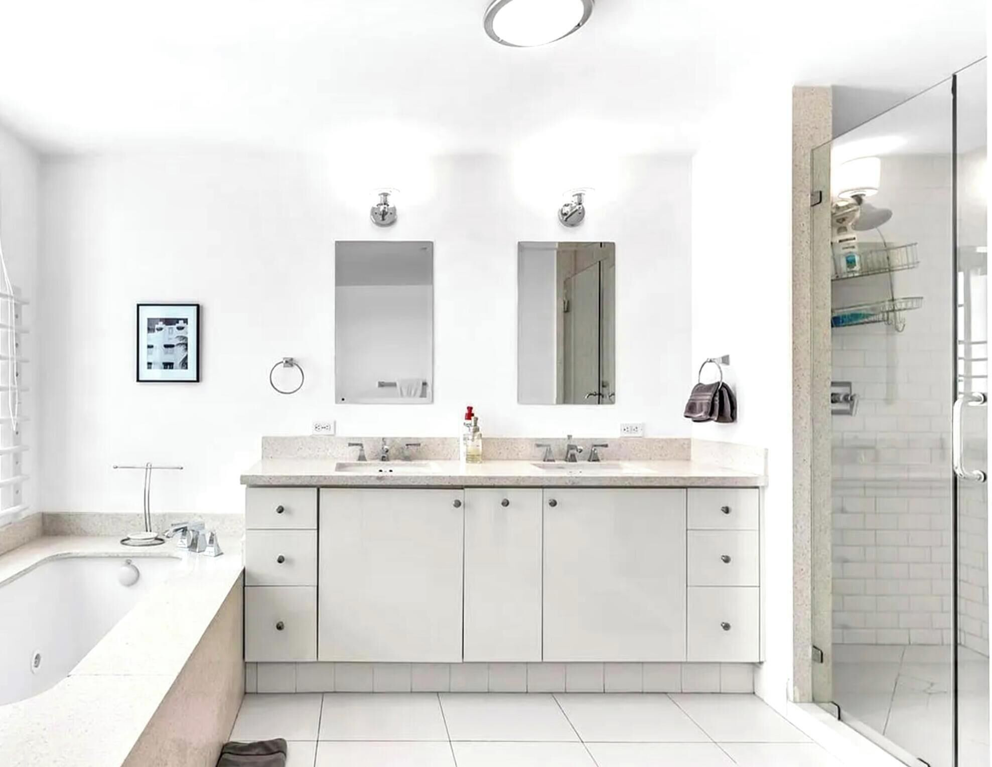A modern bathroom with a large bathtub, a shower, and a vanity with a sink and mirror.