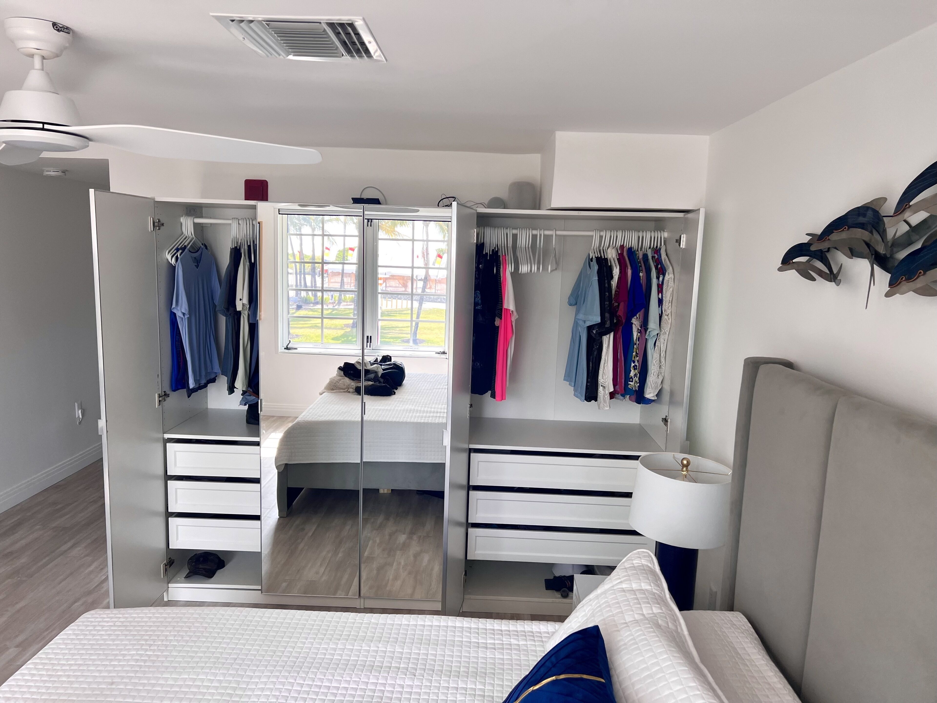 A bedroom with a bed, a wardrobe, and a mirror.