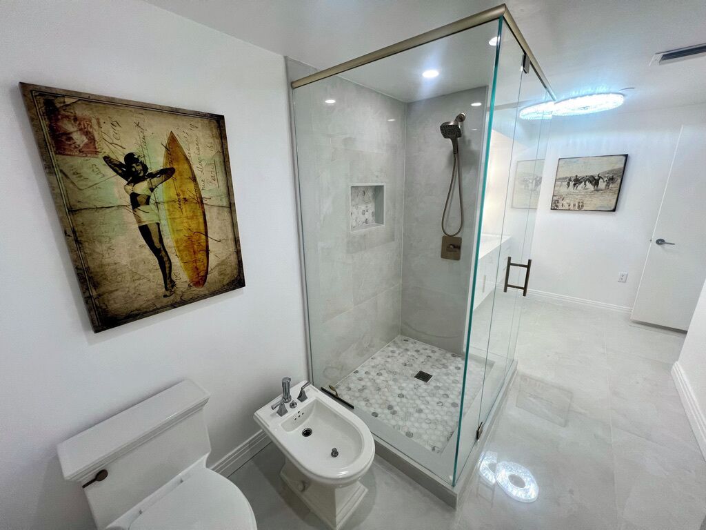 Un baño moderno con ducha de vidrio, un bidé y un inodoro.